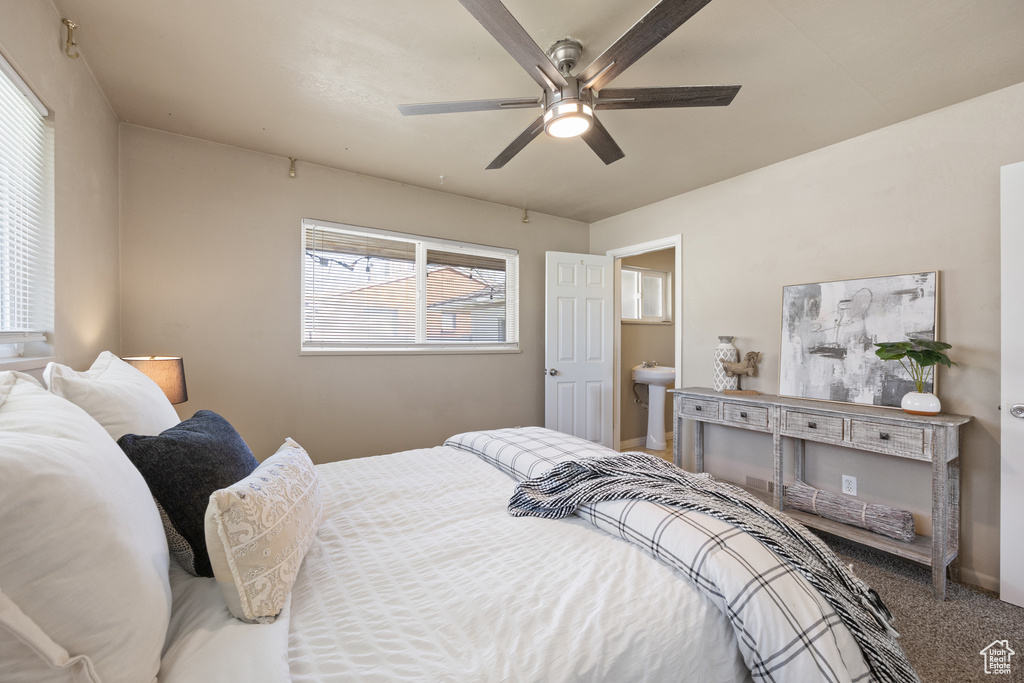 Carpeted bedroom with ceiling fan and sink