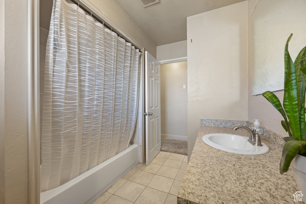 Bathroom with shower / tub combo, tile patterned flooring, and vanity