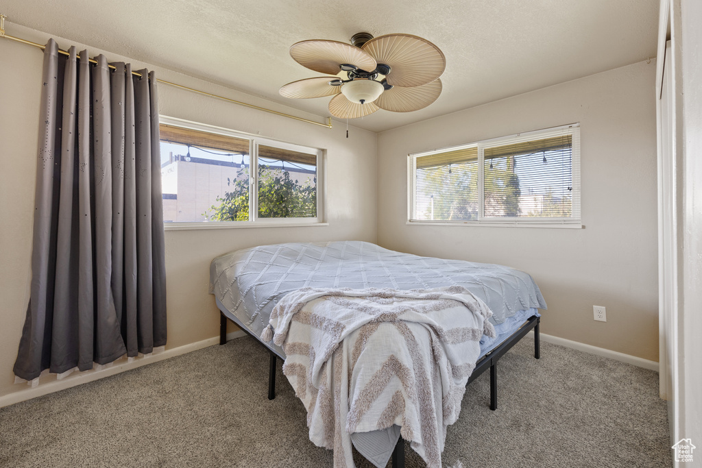 Carpeted bedroom featuring ceiling fan