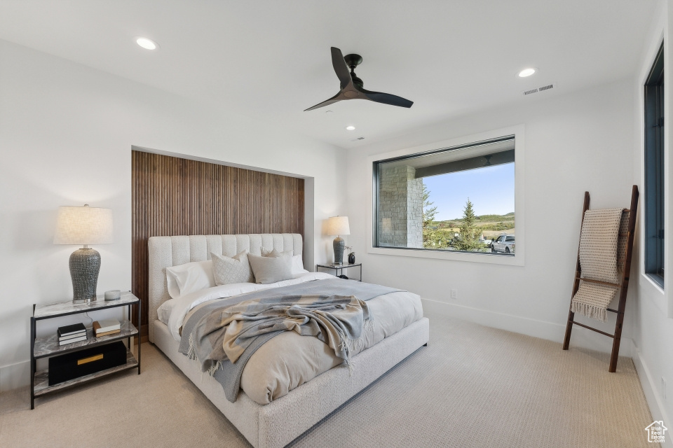 Carpeted bedroom featuring ceiling fan