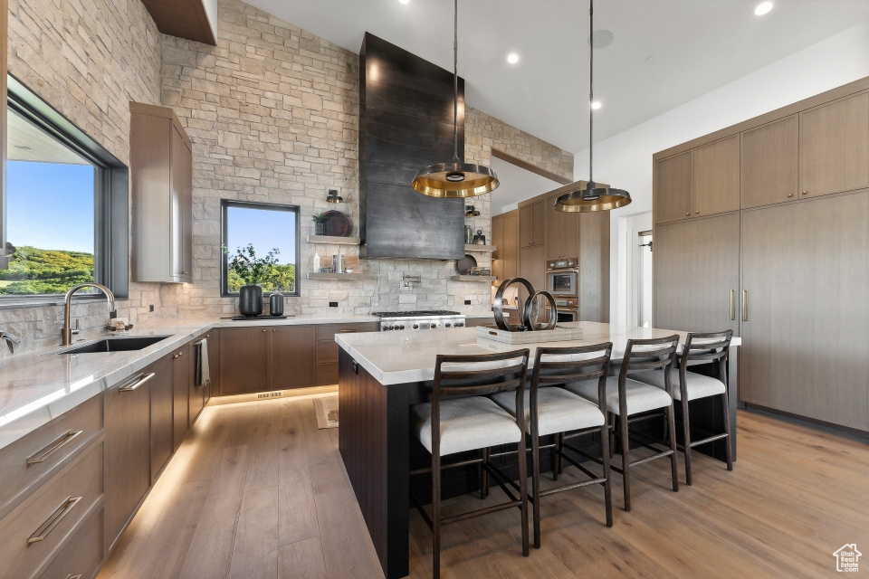 Kitchen featuring a kitchen bar, a center island, sink, and pendant lighting