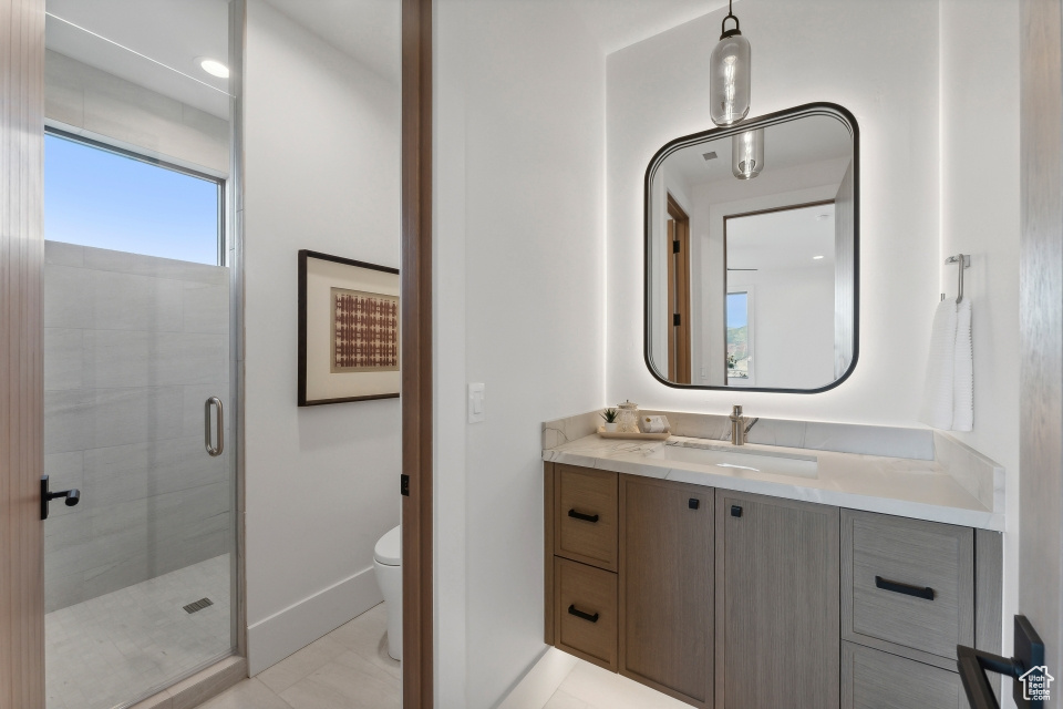 Bathroom with walk in shower, vanity, and toilet