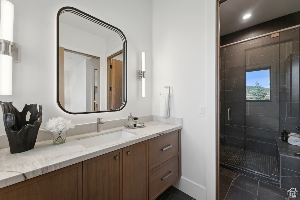 Bathroom featuring vanity, an enclosed shower, and tile patterned floors