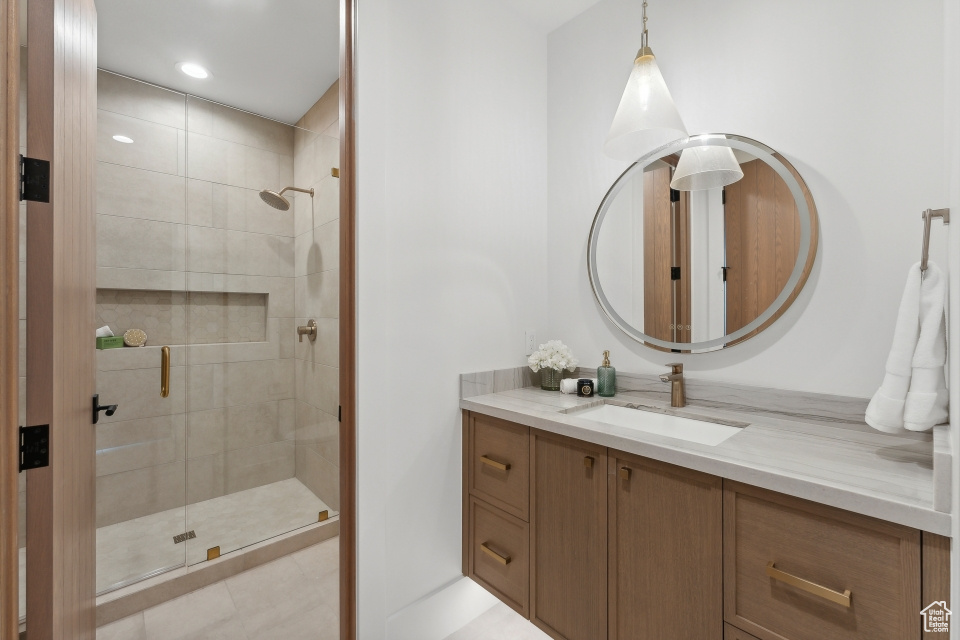 Bathroom with tile patterned floors, an enclosed shower, and vanity