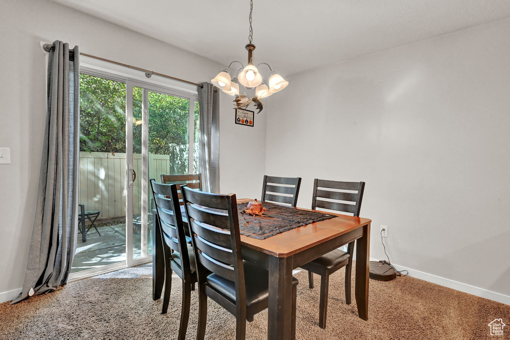 Dining space with a notable chandelier and carpet floors