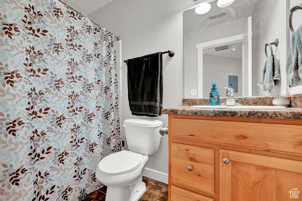 Bathroom with a shower with shower curtain, vanity, and toilet