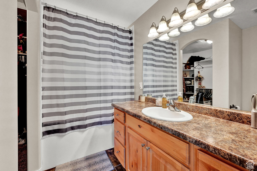 Bathroom featuring tile patterned flooring, vanity, and shower / bathtub combination with curtain