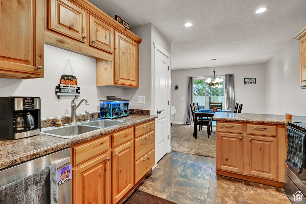 Kitchen with dark carpet, pendant lighting, sink, an inviting chandelier, and appliances with stainless steel finishes