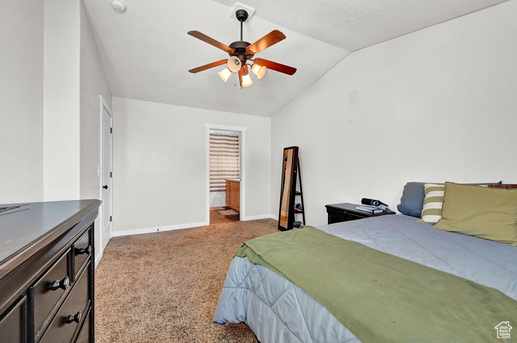 Carpeted bedroom with vaulted ceiling and ceiling fan