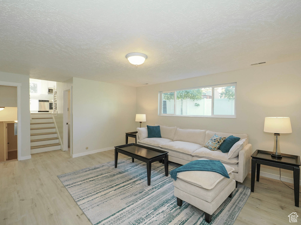 Living room featuring light hardwood / wood-style flooring and a textured ceiling