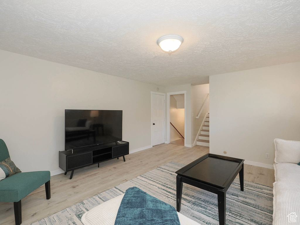 Living room featuring a textured ceiling and light wood-type flooring