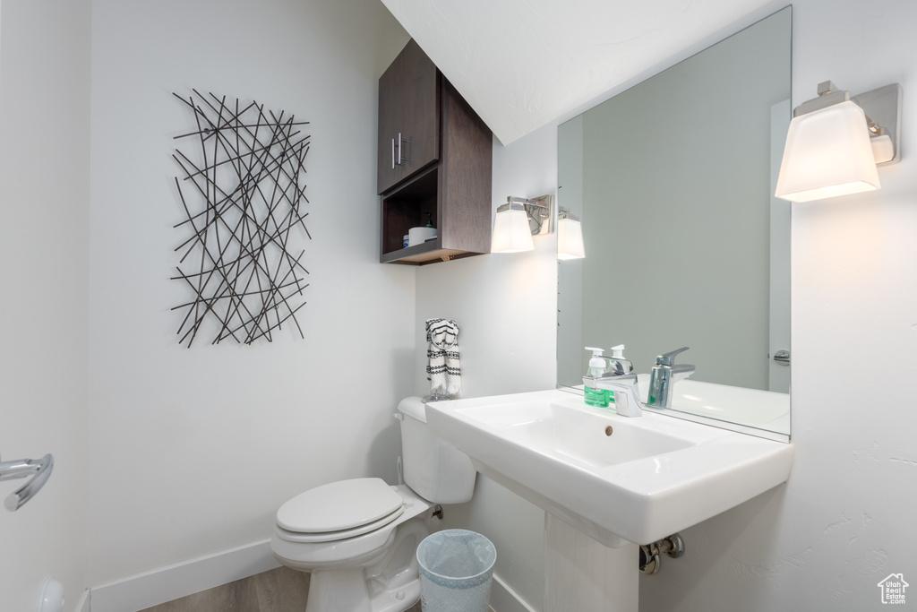 Bathroom with hardwood / wood-style flooring, sink, and toilet