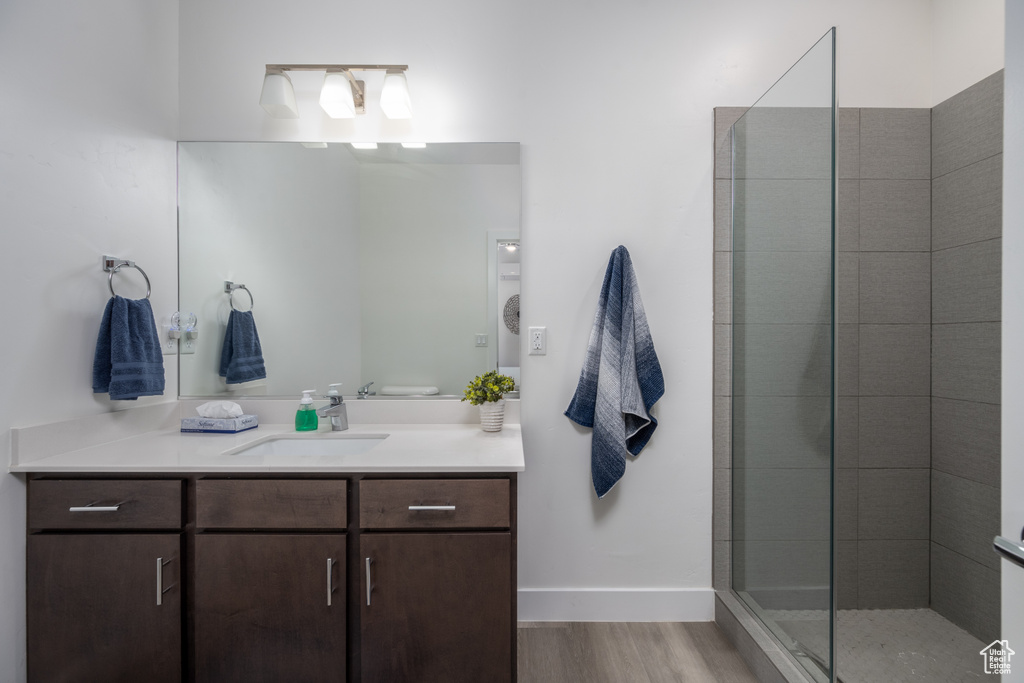 Bathroom featuring walk in shower, vanity, and hardwood / wood-style flooring