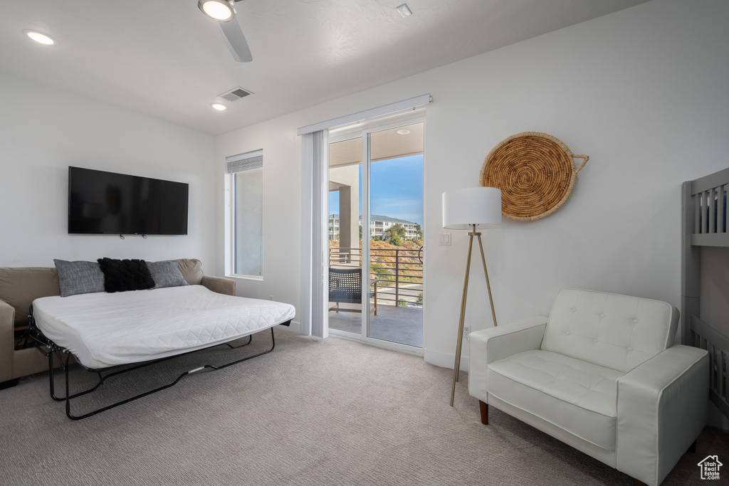 Carpeted living room featuring ceiling fan