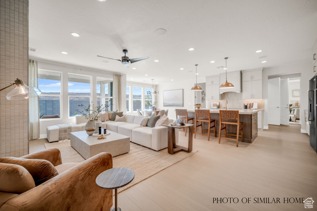 Living room featuring ceiling fan, sink, and light hardwood / wood-style flooring