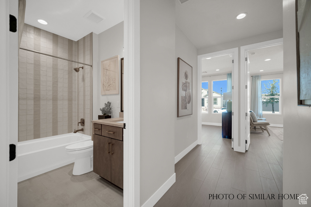 Full bathroom featuring tile patterned flooring, tiled shower / bath, toilet, and vanity