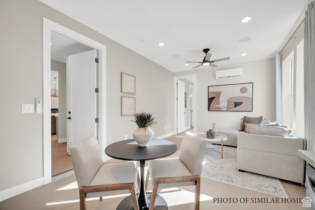 Dining space with ceiling fan, light hardwood / wood-style flooring, and a wall mounted AC