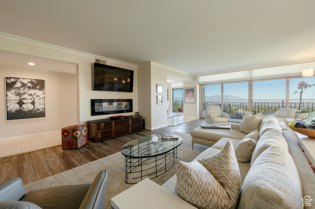 Living room with ornamental molding and hardwood / wood-style floors