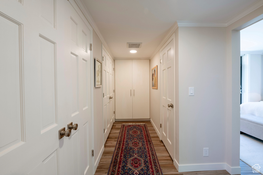 Corridor featuring hardwood / wood-style flooring and crown molding