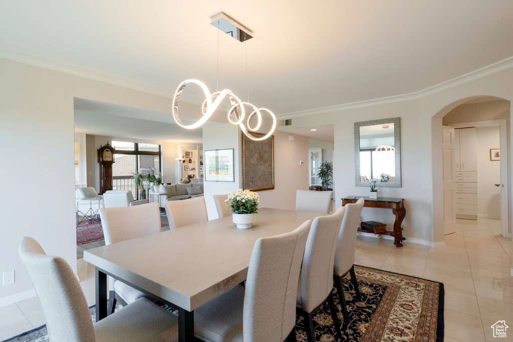 Dining room with crown molding and light tile patterned floors