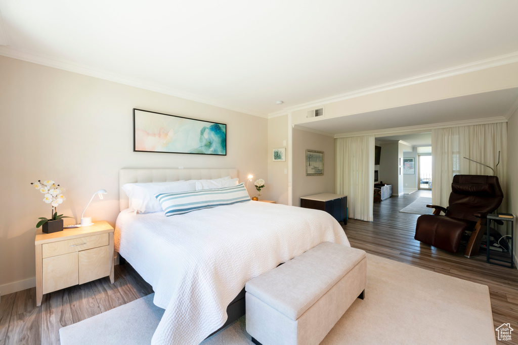 Bedroom with crown molding and hardwood / wood-style floors