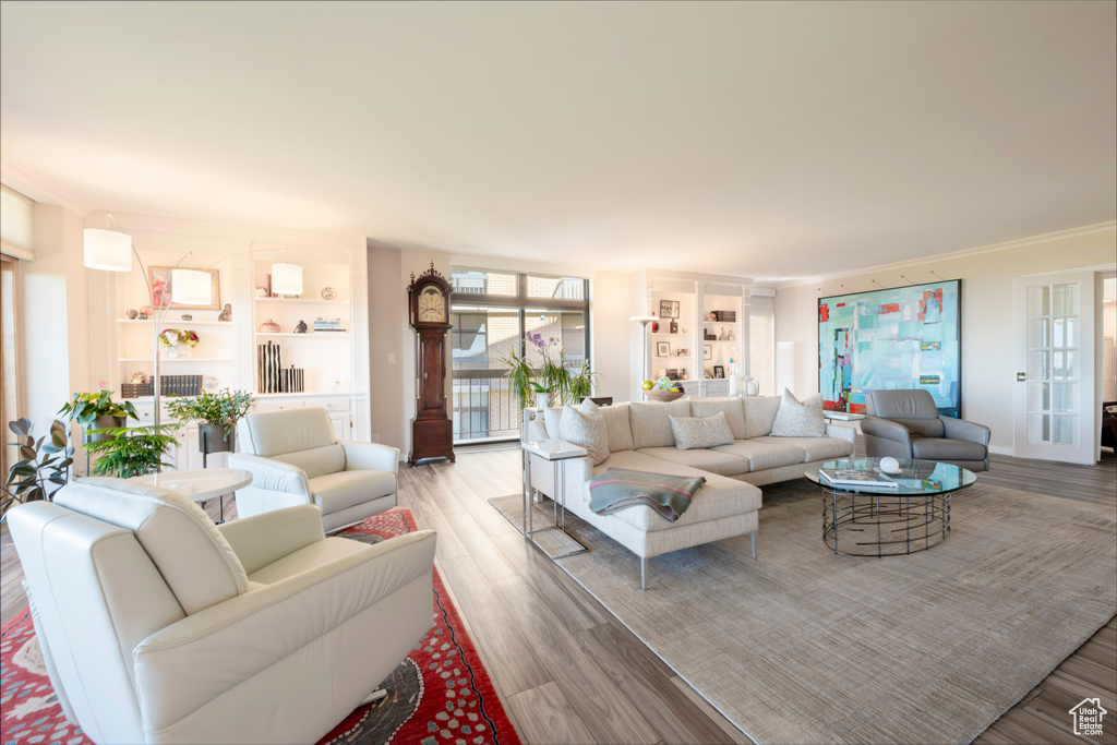 Living room with light wood-type flooring and ornamental molding