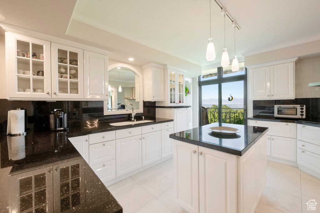 Kitchen with white cabinets, sink, tasteful backsplash, and a kitchen island