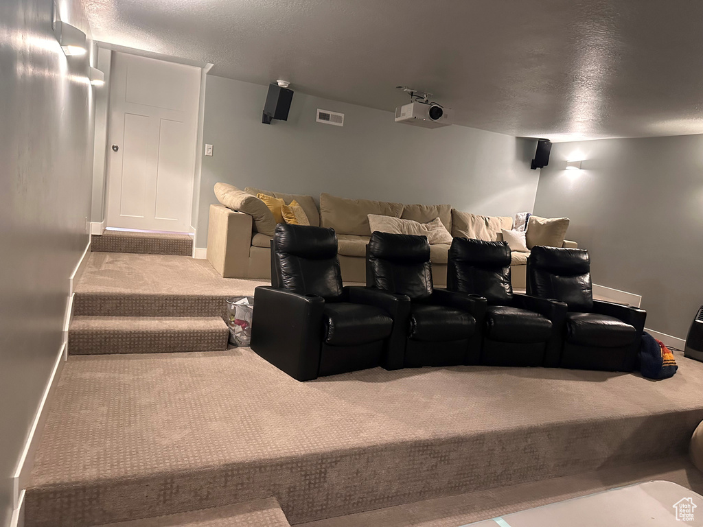 Home theater room featuring carpet and a textured ceiling