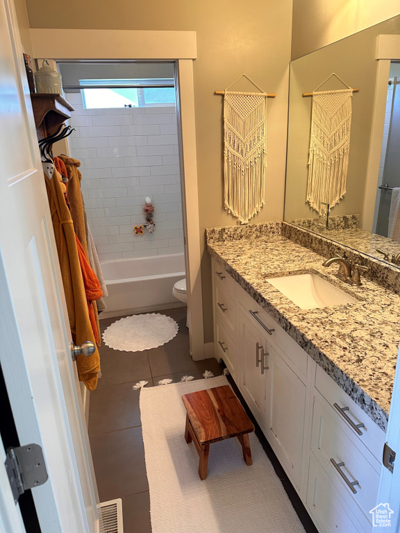 Full bathroom featuring tiled shower / bath combo, vanity, tile patterned flooring, and toilet