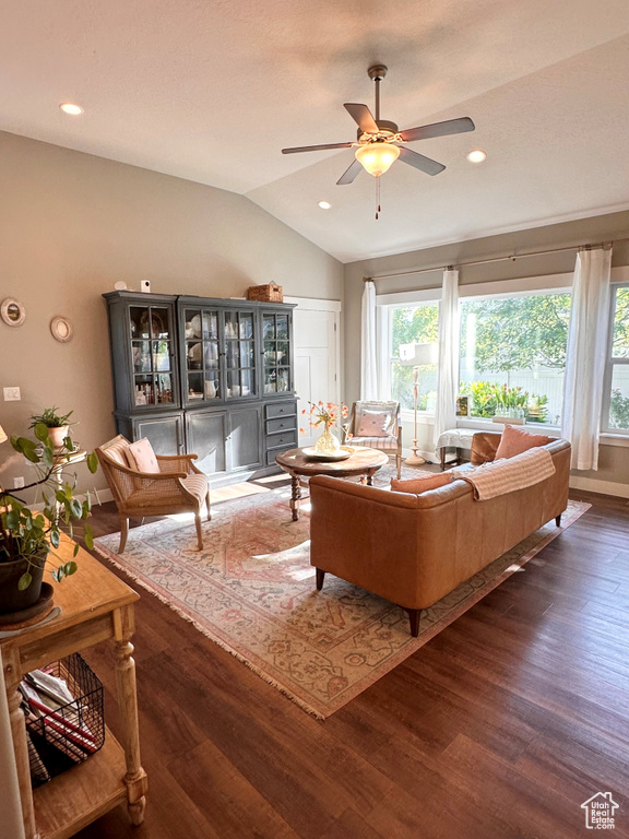 Living room featuring lofted ceiling, dark hardwood / wood-style floors, and ceiling fan