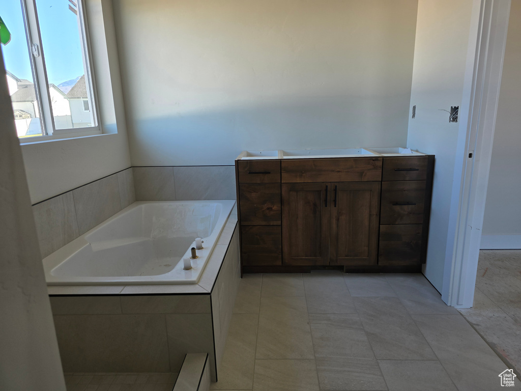 Bathroom with tile patterned flooring and tiled tub