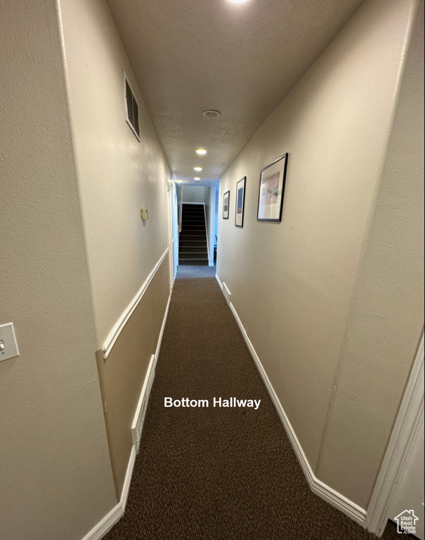 Hall with a textured ceiling and carpet