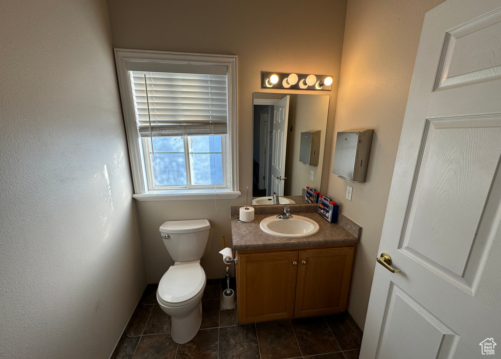 Bathroom featuring vanity, tile patterned flooring, and toilet