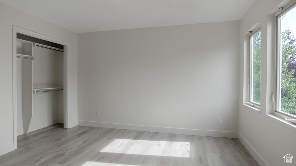 Unfurnished bedroom with light wood-type flooring and a closet