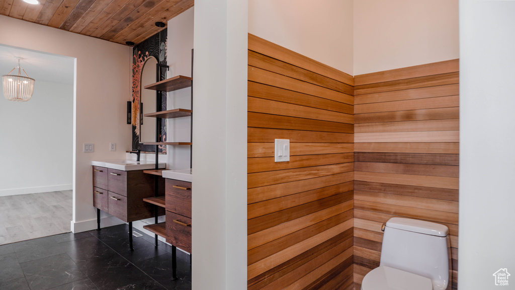 Bathroom with vanity, a chandelier, toilet, and wooden ceiling