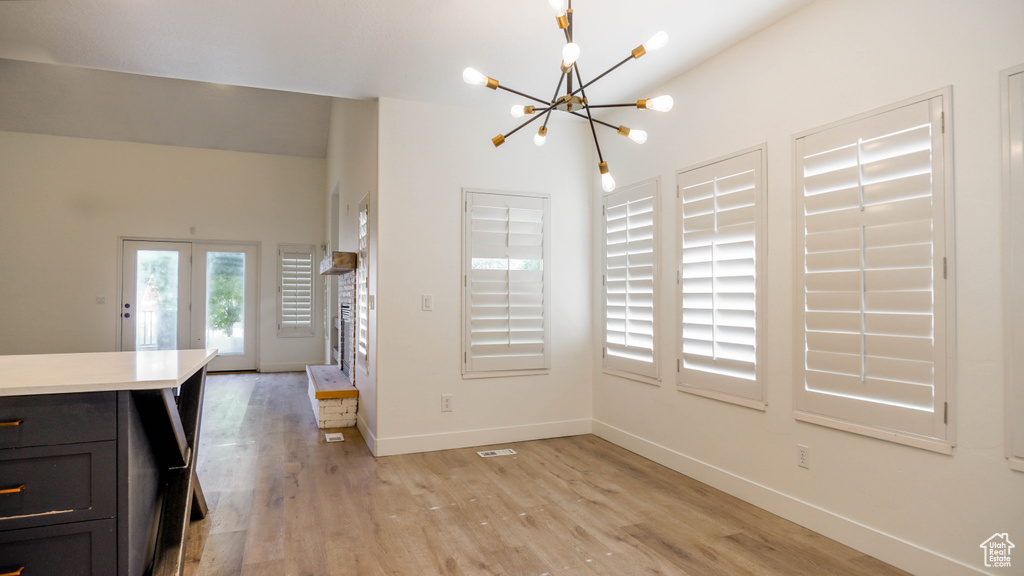 Dining area with light hardwood / wood-style flooring and a chandelier