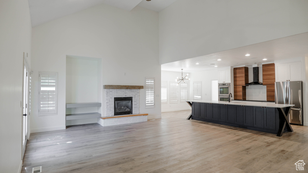 Living room with light wood-type flooring, plenty of natural light, and high vaulted ceiling