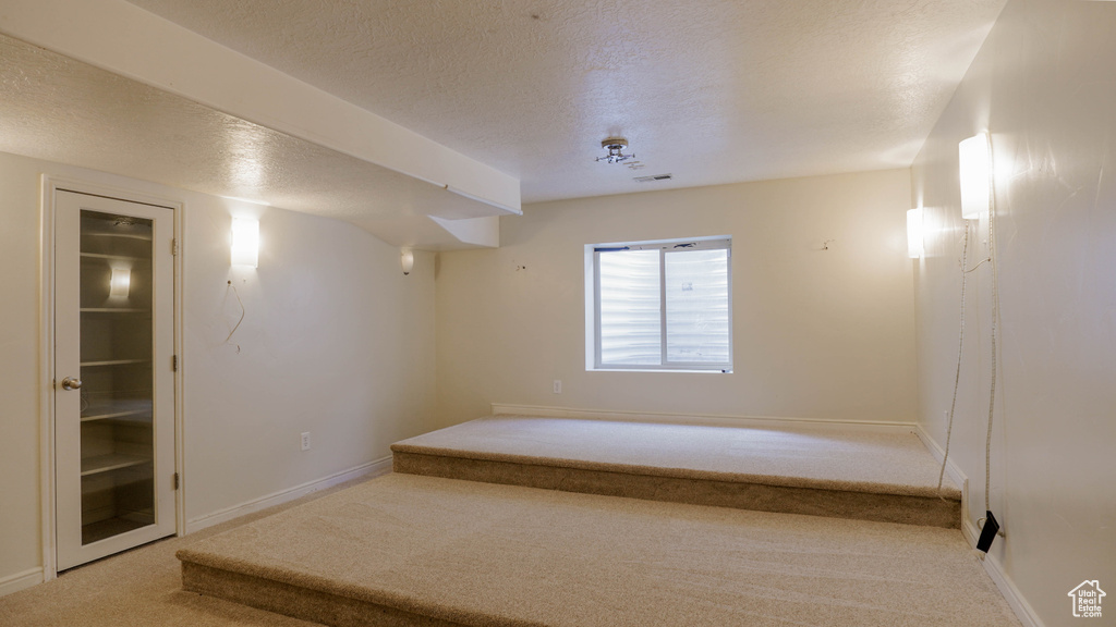 Interior space featuring carpet floors and a textured ceiling