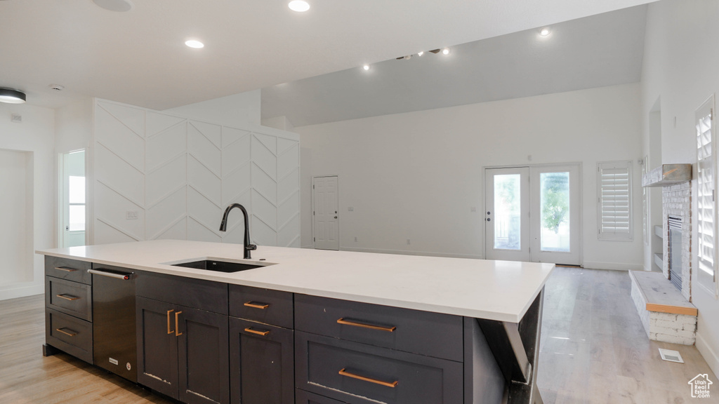 Kitchen featuring a center island with sink, light wood-type flooring, and sink