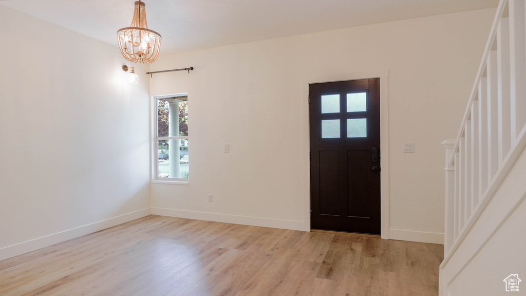 Entryway with light wood-type flooring and a chandelier