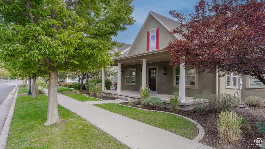 View of front of house featuring a front lawn and a porch