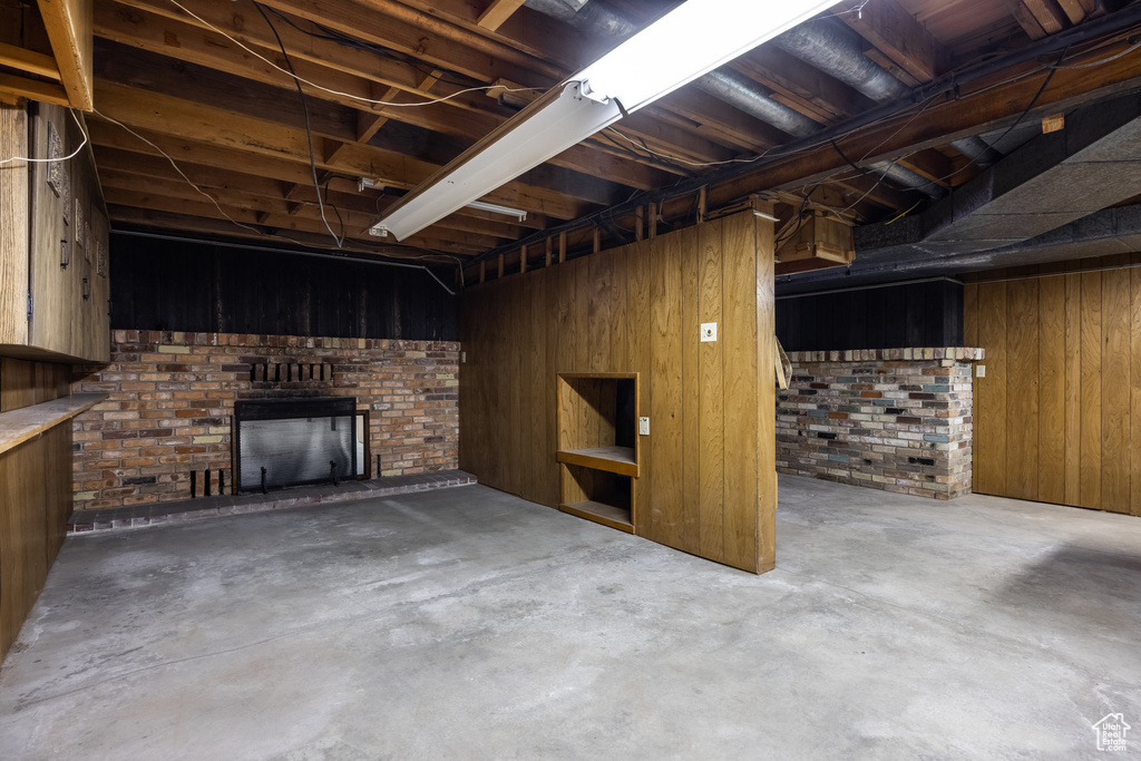 Basement featuring wooden walls and a fireplace