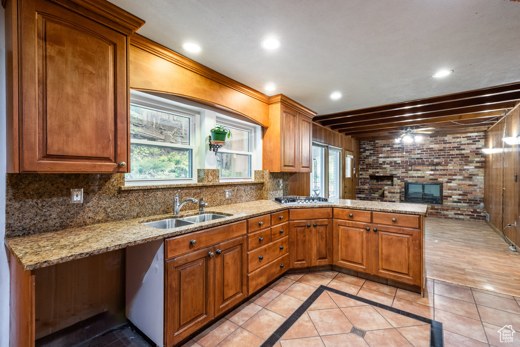 Kitchen with light stone countertops, crown molding, sink, and decorative backsplash