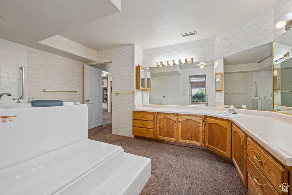 Bathroom featuring a textured ceiling, a shower, and vanity