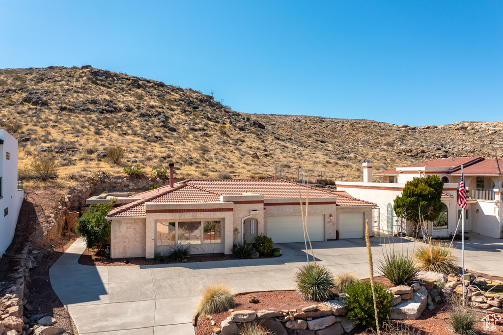 View of front facade with a mountain view and a garage