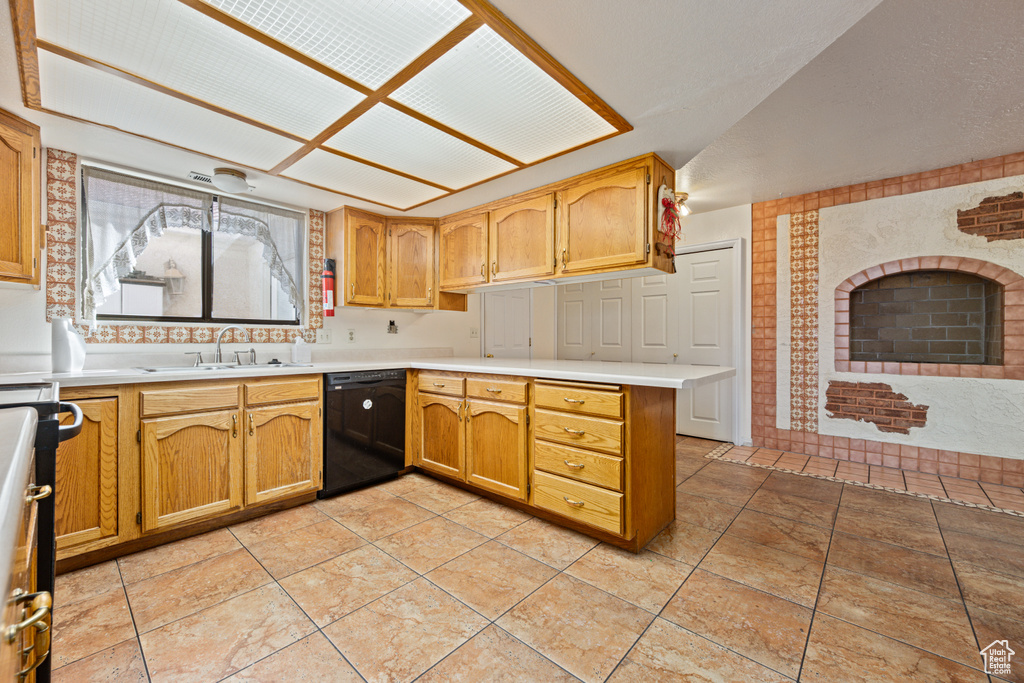 Kitchen featuring black dishwasher, sink, lofted ceiling, kitchen peninsula, and light tile patterned floors