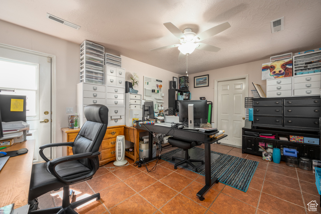 Tiled office with ceiling fan and a textured ceiling