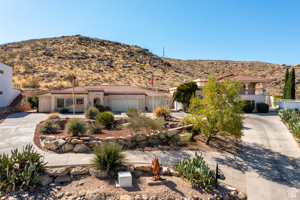 View of front of home with a mountain view and a garage