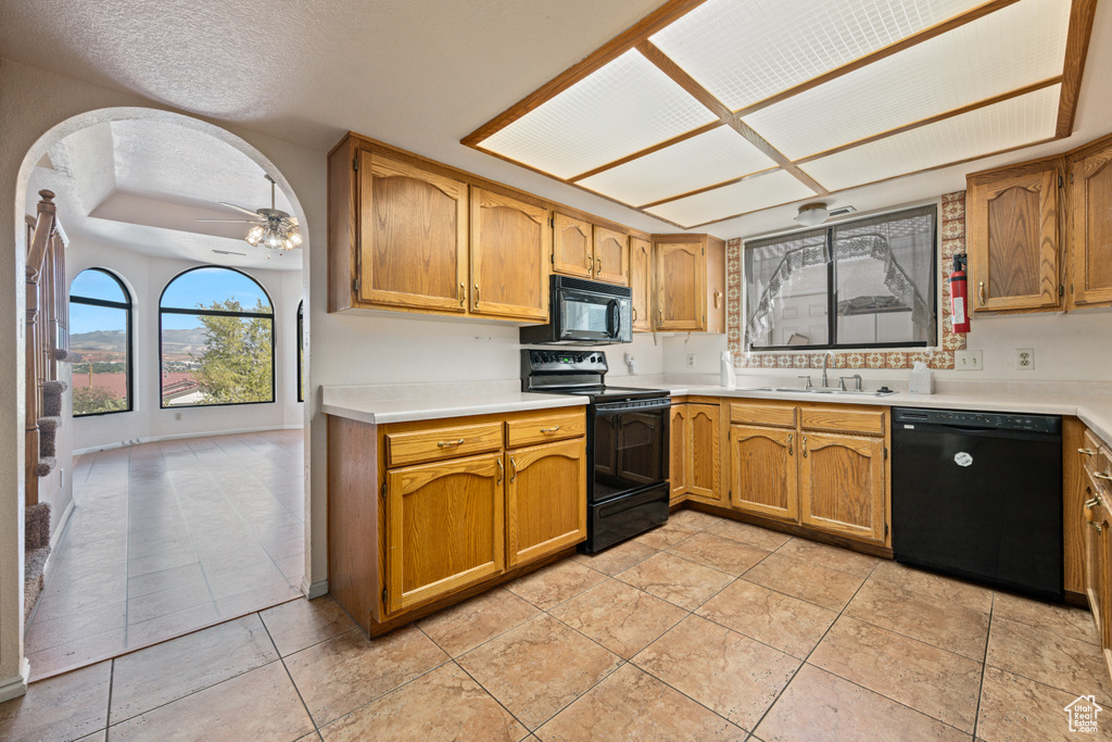 Kitchen featuring ceiling fan, light tile patterned flooring, sink, a textured ceiling, and black appliances