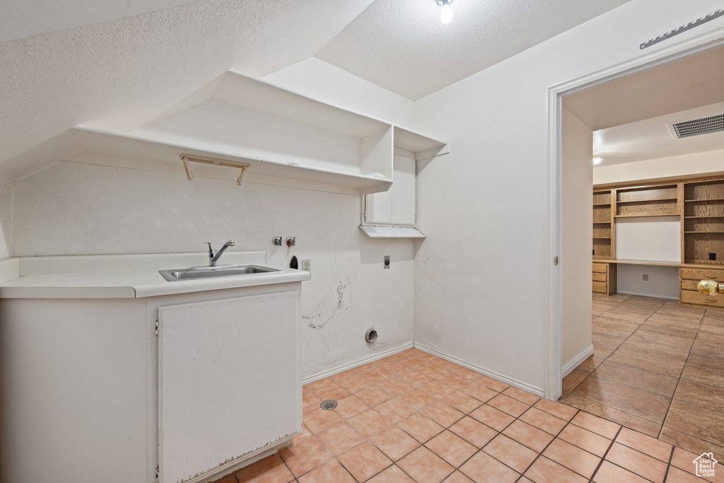 Laundry room with a textured ceiling, electric dryer hookup, washer hookup, and sink